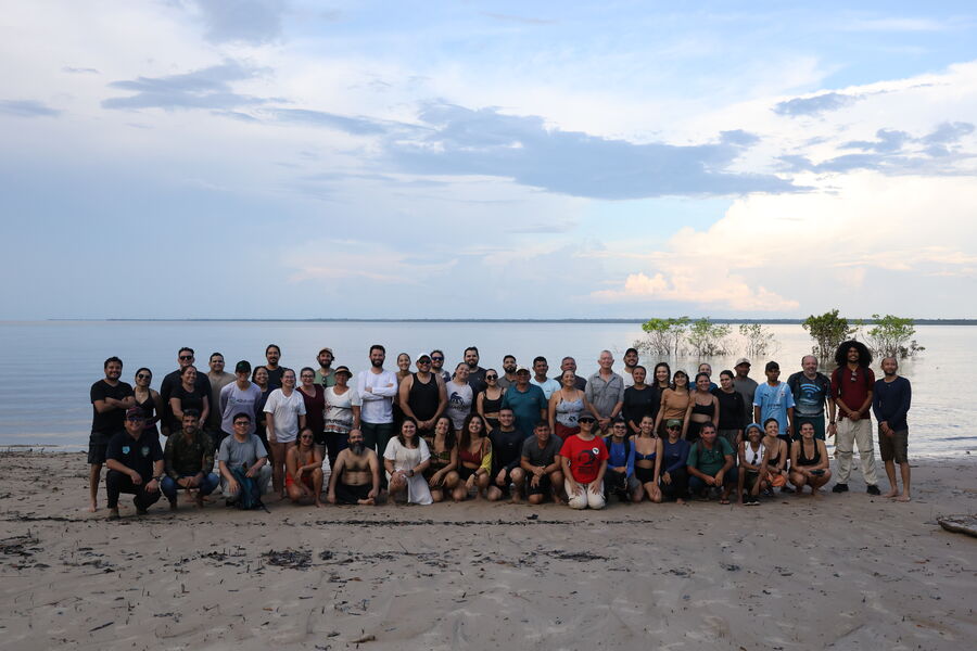 Equipe do projeto reunida à beira do lago sob um céu amplo